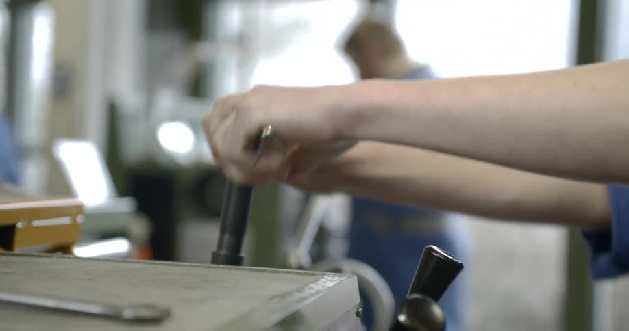 Workers operating metalworking machinery in a workshop
