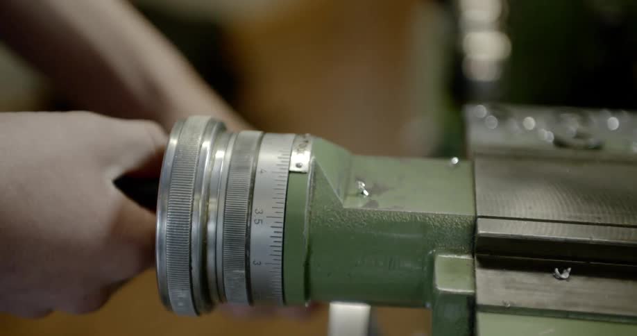 A person turns the dial on a machine in a workshop