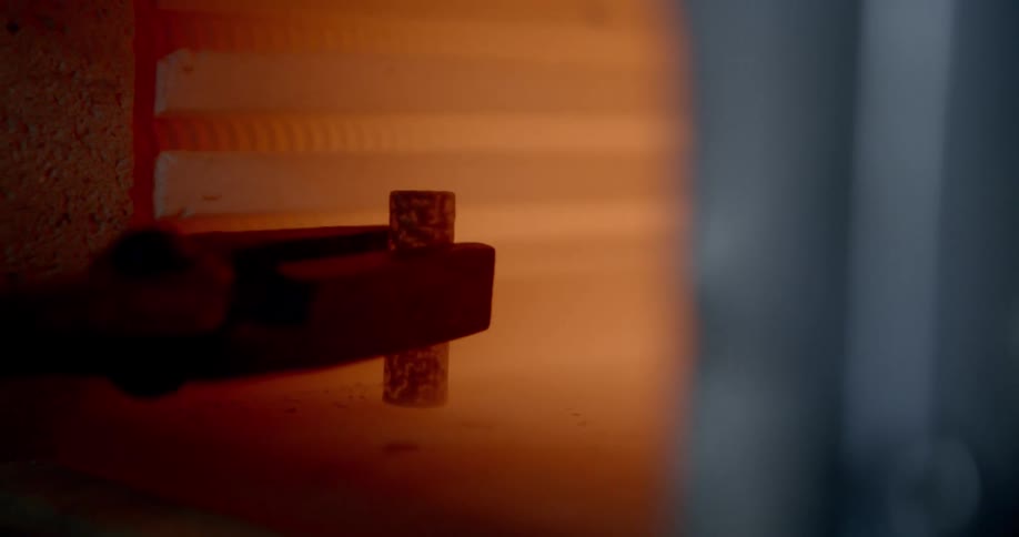 A small piece of pottery is removed from a high heat kiln