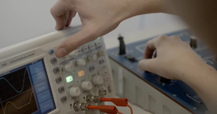 Person adjusts machine showing wave patterns