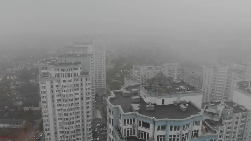 Huge housing tower blocks rise into a misty and overcast sky