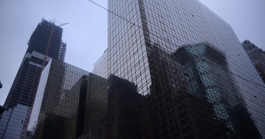 Several glass laden skyscrapers stand against a clear blue sky