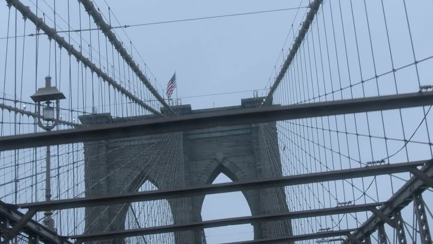 The flag blows in the wind above the bridge