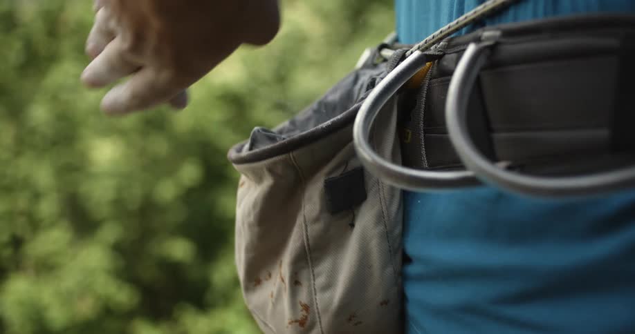 A man puts his hand in his chalk bag