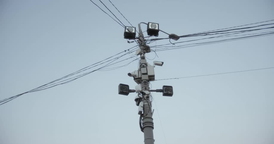 Cameras and lights are mounted high on a power line