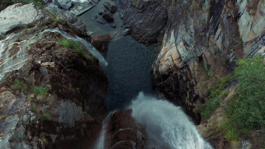 Aerial view of a water fall crashing in to a river below