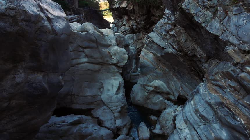 Narrow stream runs between the rocks at the base of the mountain