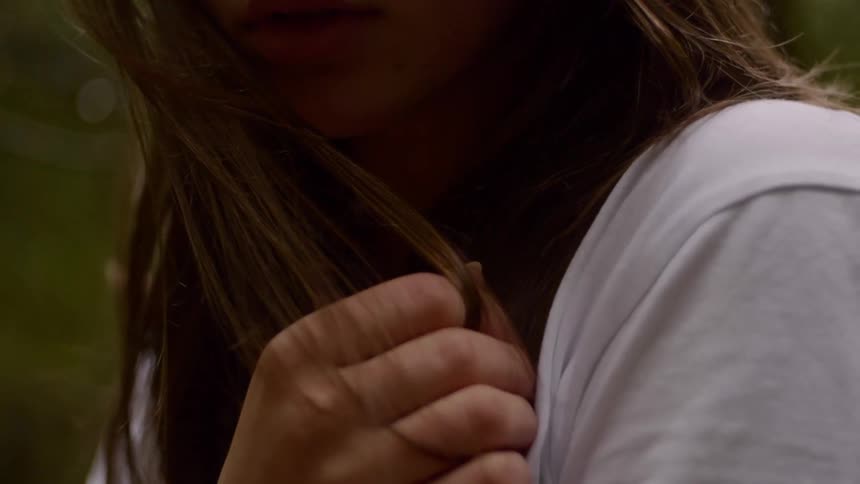 Close up of a womans hand while she stands in a forest