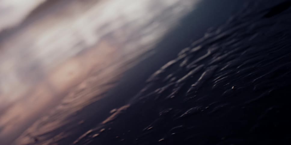Extreme close up of wet sand in the shoreline at sunset