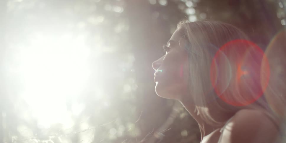 A young woman is in the middle of a forest