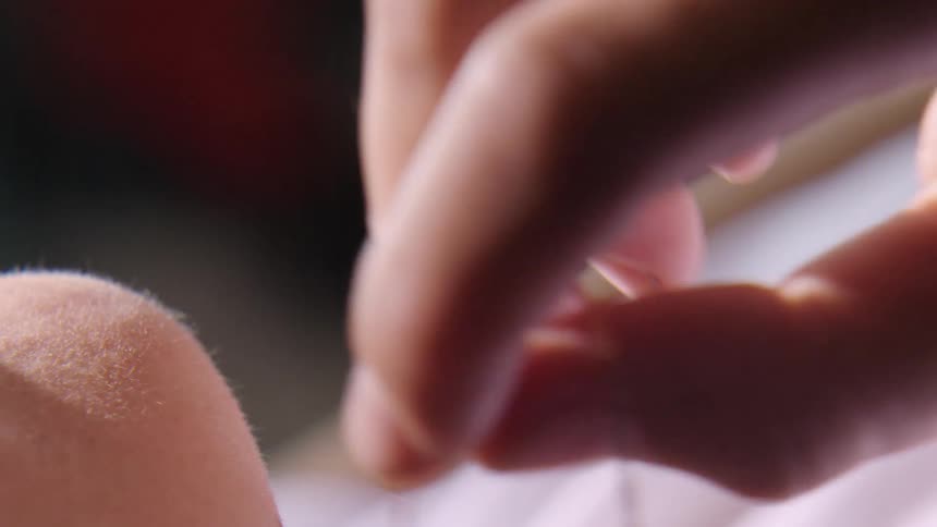 Close up of a womans face while laying on the floor playing with her necklace