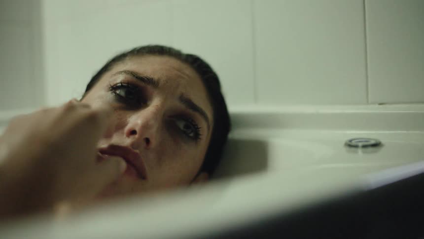 A young woman in the bathtub crying