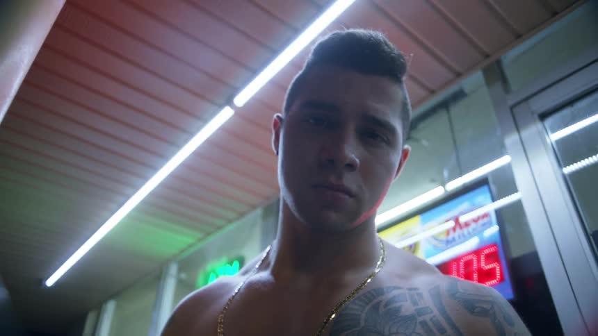 A teenager stands outside without a shirt on