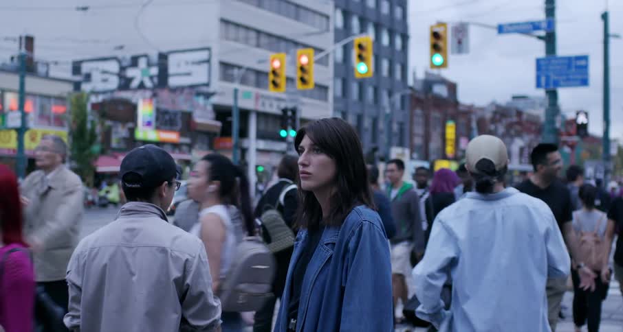 Woman stands in the corner of a busy intersection in the city