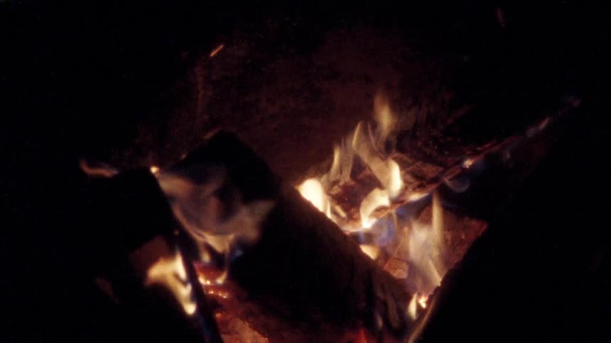 The campfire is flickering at night