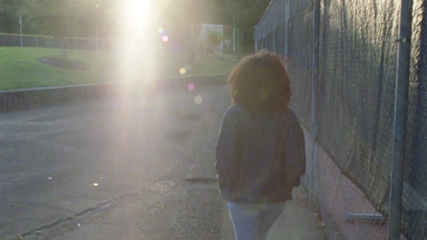 Young woman walking on a park at sunset
