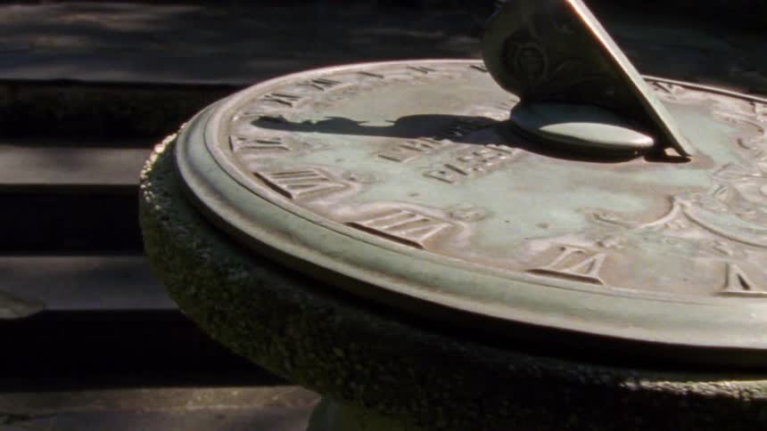 Close up of a metal sundial over a pedestal outside