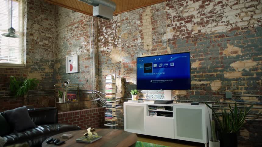 A man walks across the living area of an apartment to a television