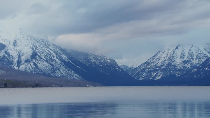 The water is calm by the mountain range