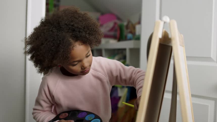 Young girl insists on model sitting still as she paints near open closet