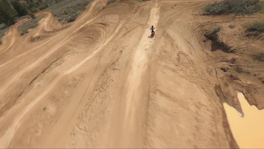 A dirt bike jumps around the course