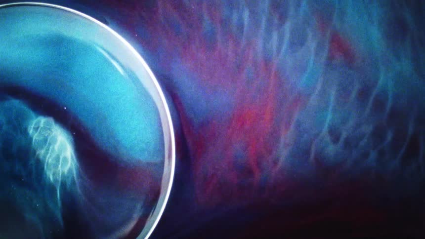 Red and blue ink swirling on the surface of a liquid