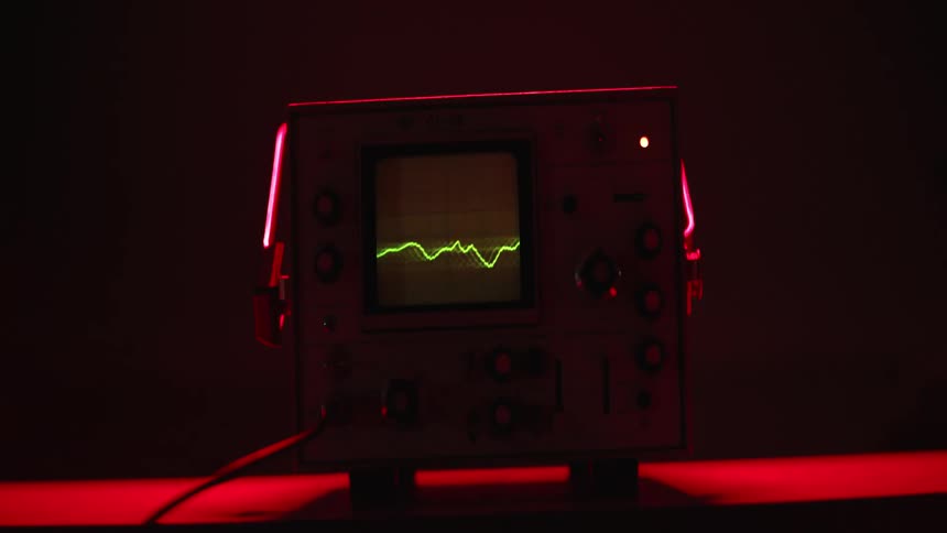 An electric scope with green lines and a red light in the background