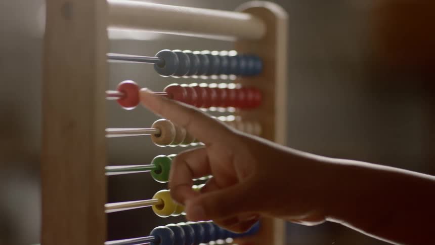 Man teaches a child how to count using the colorful beads in an abacus
