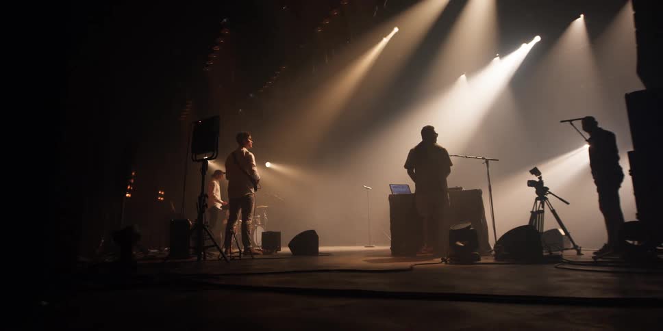 Group of musicians wait on stage under the spotlights