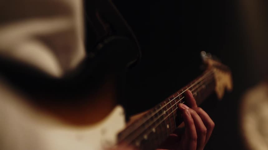 Close up of a musician playing an electric guitar on stage