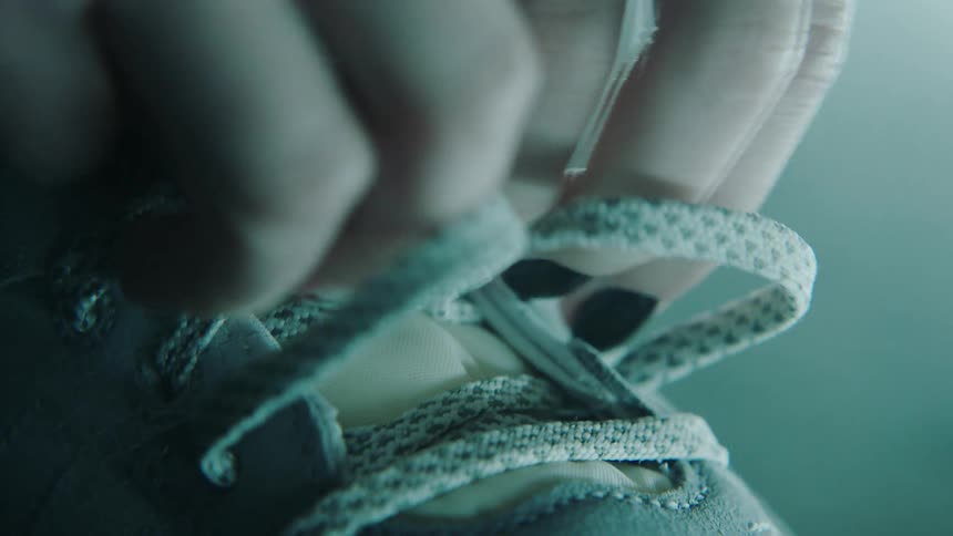 Close up of woman tying shoelaces on a sneaker