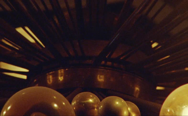 A chandelier with blinking lights with walls and the ceiling in the background