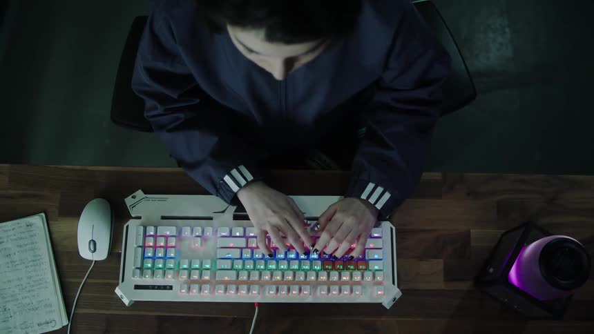 A teenager typing on a keyboard