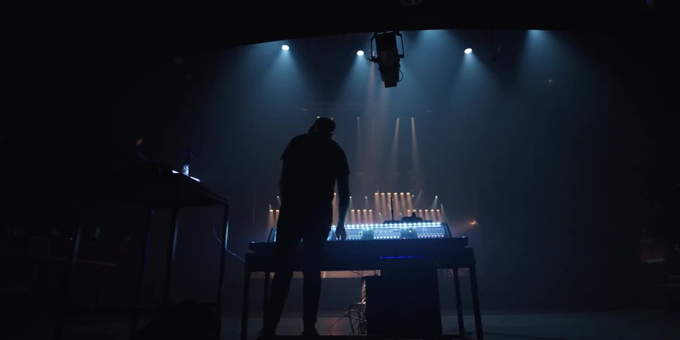 Person stand on stage near sound equipment near spotlights