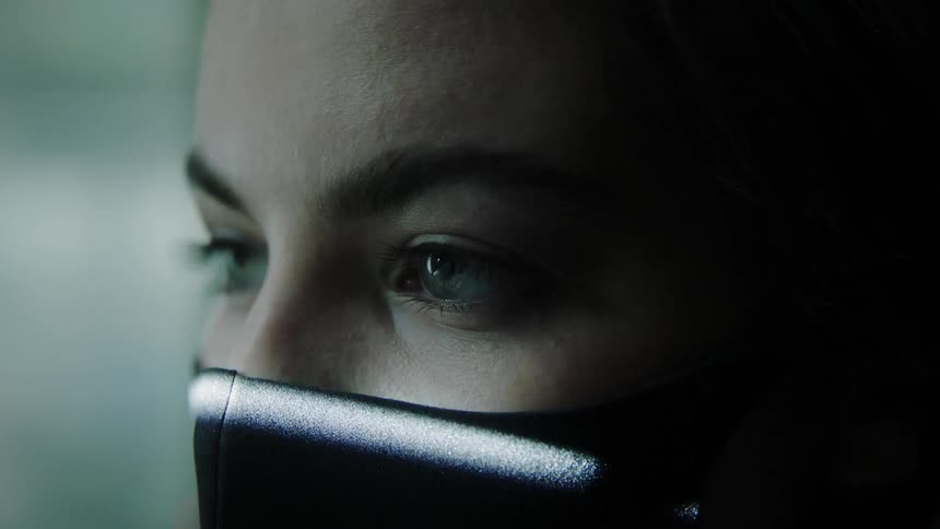 Close up of a womans face wearing a face mask being scanned by a ray of light