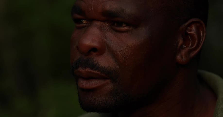 A black man looking straight ahead as he is deep in thought