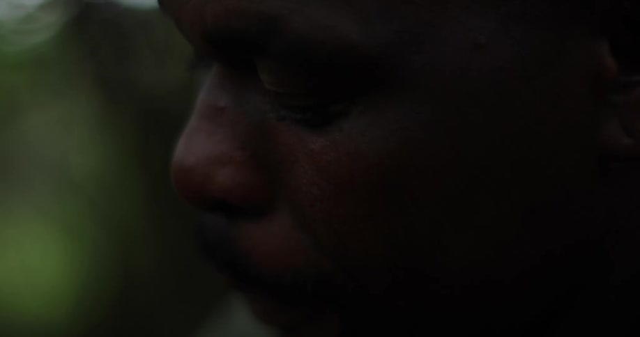 Black man looks down as he moves