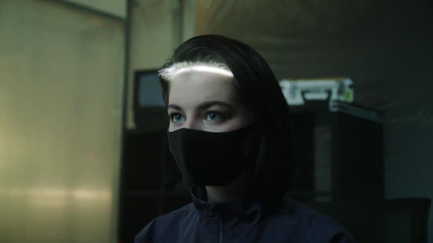 Woman wearing a facemask gets her face scanned in an office