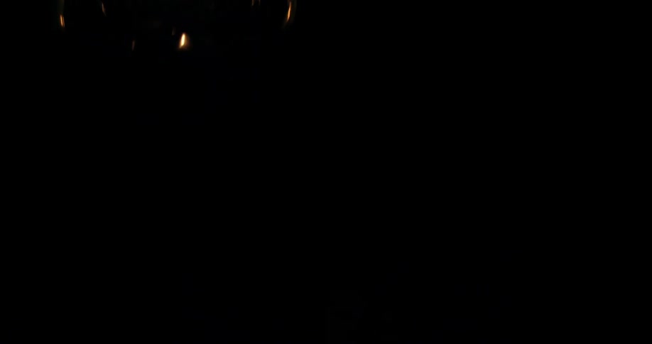 Yellow light from the flame of a vintage oil lamp lantern in a pitch black environment
