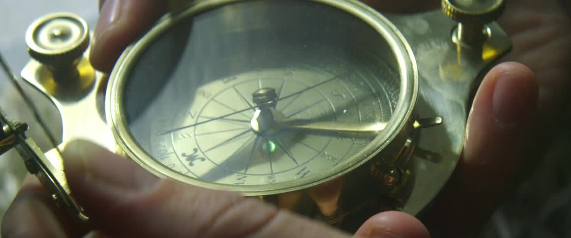 Person opens cover over compass and examines it