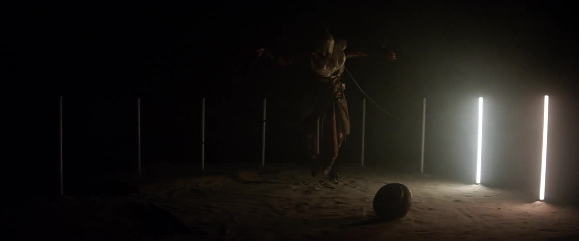 A person chained up outside with lights flashing around them