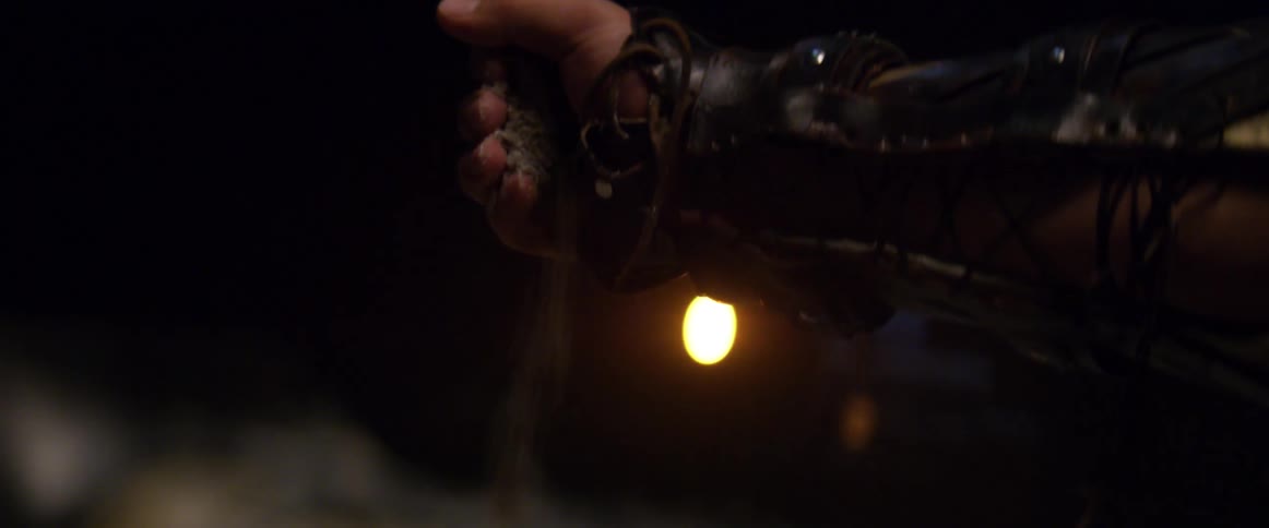 A light flashes on someone dropping sand