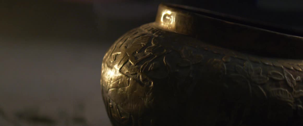 Light reflects off a decorative metal container