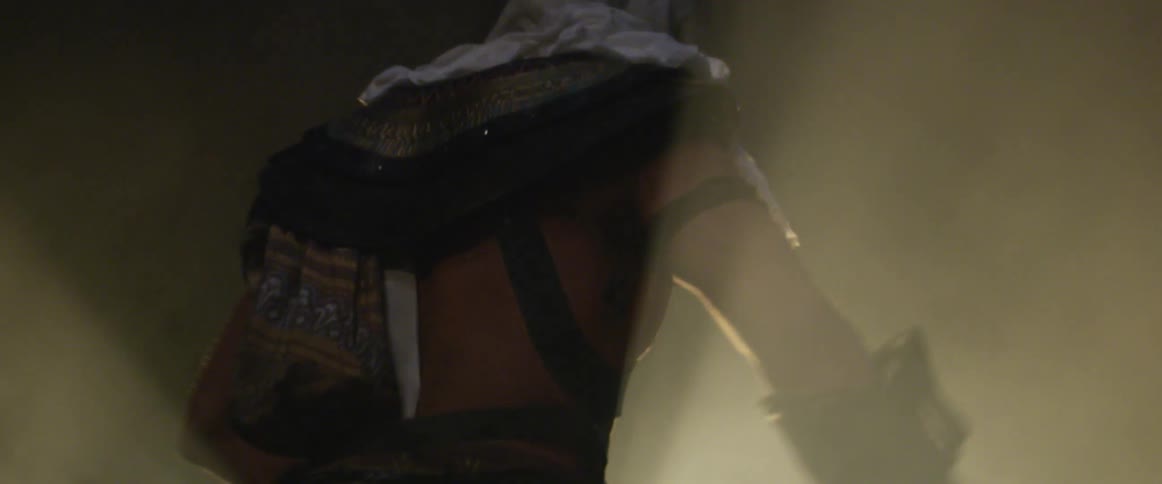 A man in costume stands in a mist and moves his arms in front of him