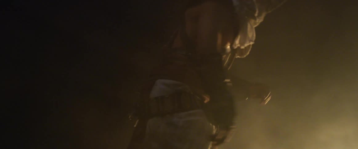 A man dressed like a medieval soldier walks toward flames