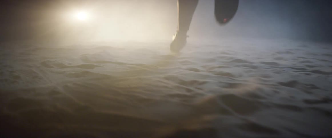 Runner runs across the ground towards a bright light