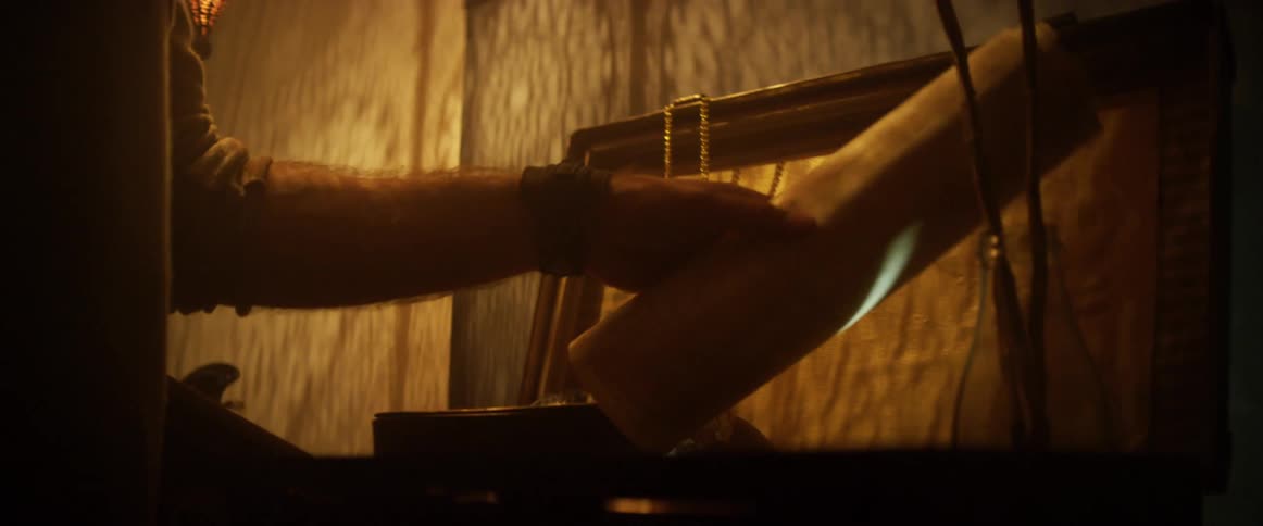 A person taking a rolled up paper from a chest with a pocket watch and a globe