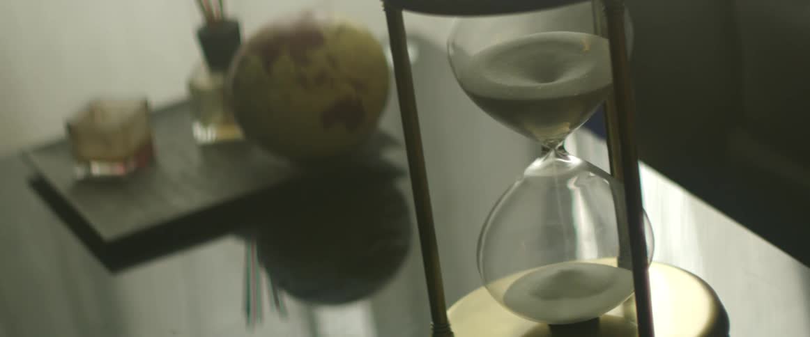 An hourglass sitting on a desk in an office