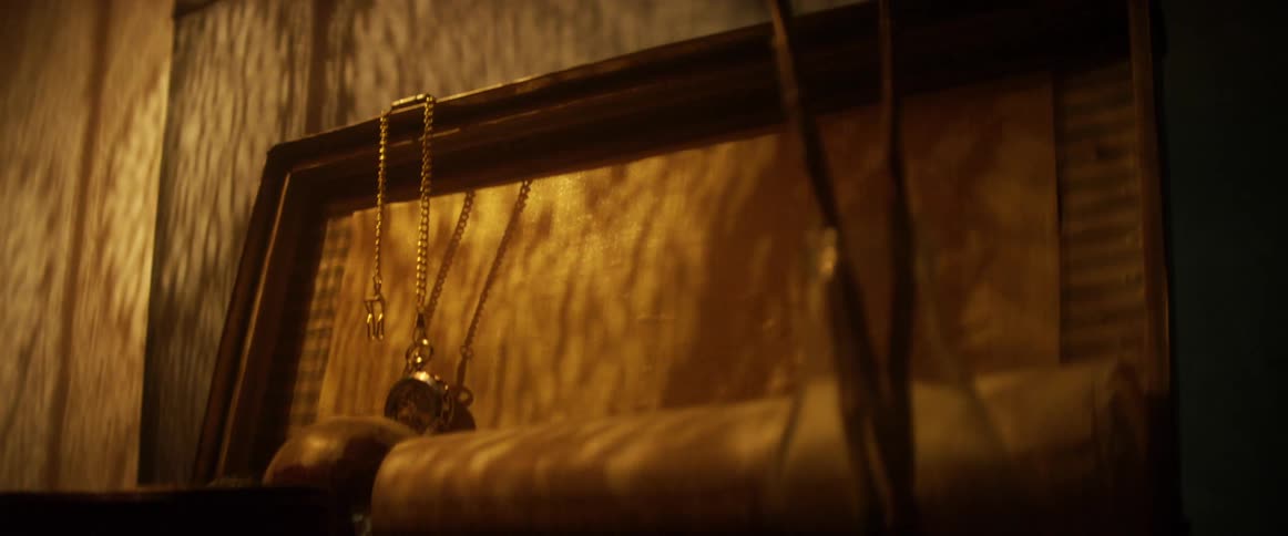 A chest with a pocket watch a globe and a vase in front of it