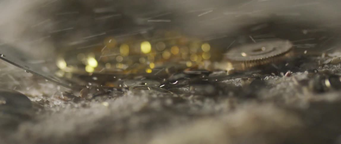 Snow blows over metal debris on the ground